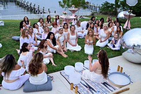 Sound healing circle with crystal bowls by the water